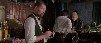 Movie still from “The Crying Game” (1992), directed by Neil Jordan – A man in a tuxedo holding a cell phone; Medium shot, Low angle