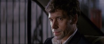 Movie still from “The Crying Game” (1992), directed by Neil Jordan – A person wearing a suit and tie; Close Up shot, Low angle