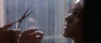 Movie still from “The Crying Game” (1992), directed by Neil Jordan – A woman looking at a person holding a pair of shears; Close Up shot, Over the shoulder angle