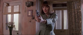 Movie still from “The Crying Game” (1992), directed by Neil Jordan – A woman holding a gun in a room; Medium shot, Low angle