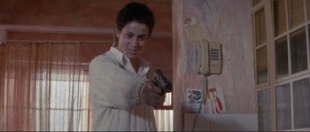 Movie still from “The Crying Game” (1992), directed by Neil Jordan – A young man holding a gun in a room; Close Up shot, Low angle