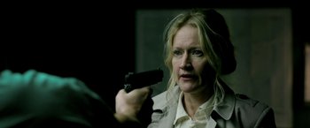 A woman holding a gun in her right hand