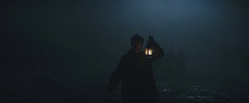 Movie still from “The Current War: Director's Cut” (2017), directed by Alfonso Gomez-Rejon – A person holding a lantern in the dark; Medium shot, Low angle
