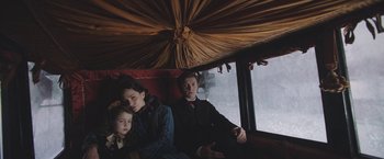 Movie still from “The Current War: Director's Cut” (2017), directed by Alfonso Gomez-Rejon – A man and a woman sitting next to a child; Medium shot, High angle