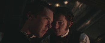 Movie still from “The Current War: Director's Cut” (2017), directed by Alfonso Gomez-Rejon – A man and a woman looking at each other in the dark; Close Up shot, Over the shoulder angle