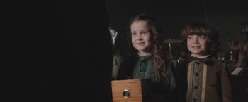 Movie still from “The Current War: Director's Cut” (2017), directed by Alfonso Gomez-Rejon – A little girl is smiling while looking at the camera; Close Up shot, Over the shoulder angle