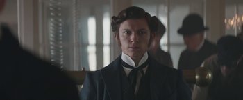 Movie still from “The Current War: Director's Cut” (2017), directed by Alfonso Gomez-Rejon – A young man in a suit and tie looking at the camera; Close Up shot, Low angle