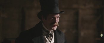 Movie still from “The Current War: Director's Cut” (2017), directed by Alfonso Gomez-Rejon – A man in a top hat with a mustache; Close Up shot, Low angle
