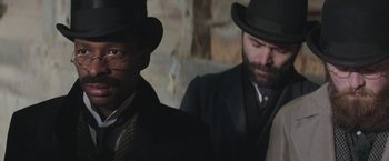 Movie still from “The Current War: Director's Cut” (2017), directed by Alfonso Gomez-Rejon – A man in a suit and a man in a top hat; Close Up shot, Over the shoulder angle