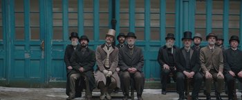 Movie still from “The Current War: Director's Cut” (2017), directed by Alfonso Gomez-Rejon – A group of men sitting next to each other on top of a bench; Wide shot, High angle