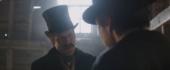 Movie still from “The Current War: Director's Cut” (2017), directed by Alfonso Gomez-Rejon – A man in a top hat talking to another man in a suit; Close Up shot, Over the shoulder angle