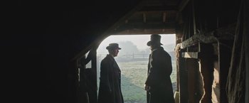 Movie still from “The Current War: Director's Cut” (2017), directed by Alfonso Gomez-Rejon – Two men are standing in a barn looking at each other; Wide shot, Over the shoulder angle