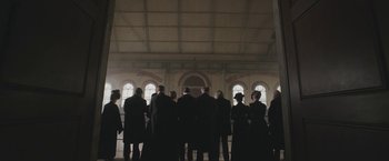 Movie still from “The Current War: Director's Cut” (2017), directed by Alfonso Gomez-Rejon – A group of people standing in front of a window; Wide shot, Low angle