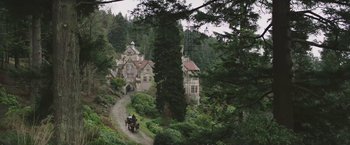 Movie still from “The Current War: Director's Cut” (2017), directed by Alfonso Gomez-Rejon – A horse drawn carriage traveling down a road in a wooded area; Extreme Wide shot, High angle