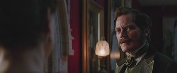 Movie still from “The Current War: Director's Cut” (2017), directed by Alfonso Gomez-Rejon – A person with a mustache in a room; Close Up shot, Over the shoulder angle