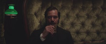 Movie still from “The Current War: Director's Cut” (2017), directed by Alfonso Gomez-Rejon – A man in a suit drinking a glass of wine; Close Up shot, Low angle