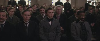 Movie still from “The Current War: Director's Cut” (2017), directed by Alfonso Gomez-Rejon – A group of men in suits and ties standing in front of a crowd; Medium shot, Over the shoulder angle