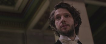 Movie still from “The Current War: Director's Cut” (2017), directed by Alfonso Gomez-Rejon – A person wearing a suit and tie; Close Up shot, Low angle