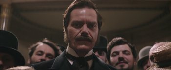 Movie still from “The Current War: Director's Cut” (2017), directed by Alfonso Gomez-Rejon – A person wearing a suit and a tie; Close Up shot, Low angle