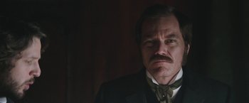 Movie still from “The Current War: Director's Cut” (2017), directed by Alfonso Gomez-Rejon – A person wearing a suit and tie; Close Up shot, Over the shoulder angle