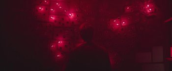 Movie still from “The Current War: Director's Cut” (2017), directed by Alfonso Gomez-Rejon – A person standing in front of a wall of lights; Medium shot, Overhead angle