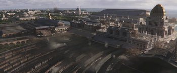 Movie still from “The Current War: Director's Cut” (2017), directed by Alfonso Gomez-Rejon – An aerial view of a train station with steam coming out of it; Extreme Wide shot, High angle