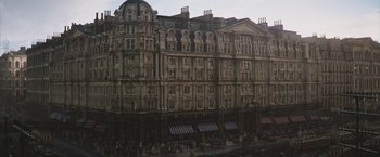 Movie still from “The Current War: Director's Cut” (2017), directed by Alfonso Gomez-Rejon – A large building with many windows on the side of the building; Extreme Wide shot, Low angle