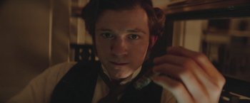 Movie still from “The Current War: Director's Cut” (2017), directed by Alfonso Gomez-Rejon – A man in a suit and tie holding a piece of paper; Close Up shot, Over the shoulder angle