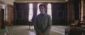 Movie still from “The Current War: Director's Cut” (2017), directed by Alfonso Gomez-Rejon – A man in a suit standing in front of a piano; Medium shot, Low angle