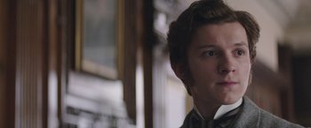 Movie still from “The Current War: Director's Cut” (2017), directed by Alfonso Gomez-Rejon – A young man in a suit looking at the camera; Close Up shot, Over the shoulder angle