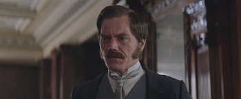 Movie still from “The Current War: Director's Cut” (2017), directed by Alfonso Gomez-Rejon – A man that is wearing a suit and tie; Close Up shot, Over the shoulder angle