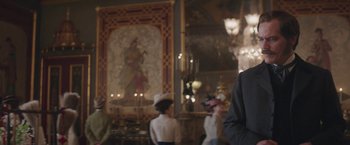 Movie still from “The Current War: Director's Cut” (2017), directed by Alfonso Gomez-Rejon – A group of people standing in front of a painting; Medium shot, Over the shoulder angle