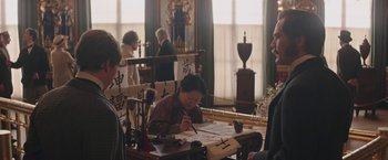 Movie still from “The Current War: Director's Cut” (2017), directed by Alfonso Gomez-Rejon – A woman is writing on a piece of paper; Medium shot, Over the shoulder angle