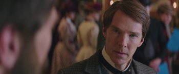 Movie still from “The Current War: Director's Cut” (2017), directed by Alfonso Gomez-Rejon – A man in a suit standing in front of a group of people; Close Up shot, Over the shoulder angle