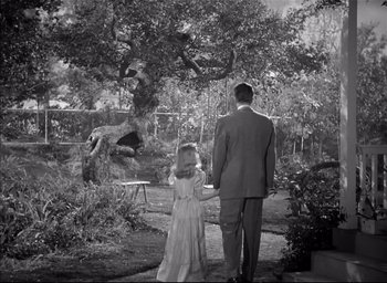 Movie still from “The Curse of the Cat People” (1944), directed by Robert Wise – A man and a little girl are walking in a garden; Wide shot, High angle