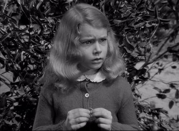 Movie still from “The Curse of the Cat People” (1944), directed by Robert Wise – A young girl is holding her hands in front of a tree; Close Up shot, High angle