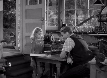Movie still from “The Curse of the Cat People” (1944), directed by Robert Wise – A man and a little girl sitting at a wooden table; Wide shot, High angle