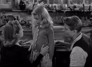 Movie still from “The Curse of the Cat People” (1944), directed by Robert Wise – A young girl is being examined by two men; Medium shot, Over the shoulder angle