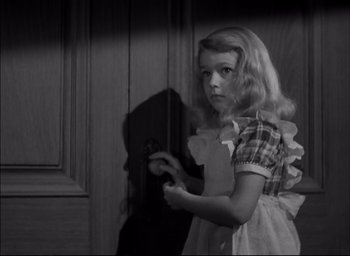 Movie still from “The Curse of the Cat People” (1944), directed by Robert Wise – A young girl in a dress is holding a mirror; Medium shot, High angle