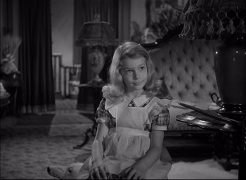 Movie still from “The Curse of the Cat People” (1944), directed by Robert Wise – A young girl sitting on the ground in a living room; Medium shot, High angle