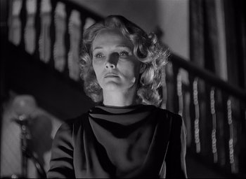 Movie still from “The Curse of the Cat People” (1944), directed by Robert Wise – A black and white photo of a woman in front of a staircase; Medium shot, Low angle