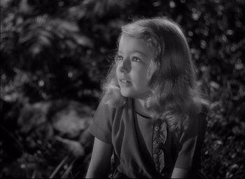 Movie still from “The Curse of the Cat People” (1944), directed by Robert Wise – A little girl sitting in front of some bushes; Close Up shot, High angle