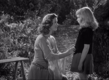Movie still from “The Curse of the Cat People” (1944), directed by Robert Wise – A woman and a little girl talking to each other; Medium shot, Over the shoulder angle