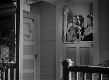 Movie still from “The Curse of the Cat People” (1944), directed by Robert Wise – A black and white photo of a woman and two children; Medium shot, Low angle