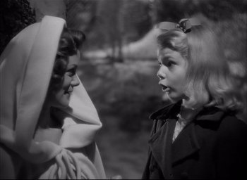 Movie still from “The Curse of the Cat People” (1944), directed by Robert Wise – Two young girls talking to each other in a park; Close Up shot, Over the shoulder angle