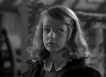 Movie still from “The Curse of the Cat People” (1944), directed by Robert Wise – A young girl with long blonde hair wearing a black dress; Close Up shot, Over the shoulder angle