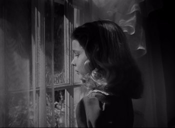 Movie still from “The Curse of the Cat People” (1944), directed by Robert Wise – A woman standing in front of a window with smoke coming out of it; Close Up shot, Low angle