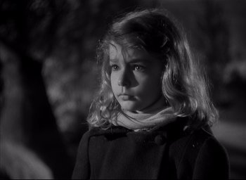 Movie still from “The Curse of the Cat People” (1944), directed by Robert Wise – A little girl with long blonde hair wearing a black coat; Close Up shot, High angle