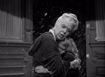 Movie still from “The Curse of the Cat People” (1944), directed by Robert Wise – Two women embracing each other outside a building; Medium shot, Low angle