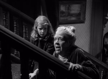 Movie still from “The Curse of the Cat People” (1944), directed by Robert Wise – An older woman and a young girl on a staircase; Medium shot, Low angle